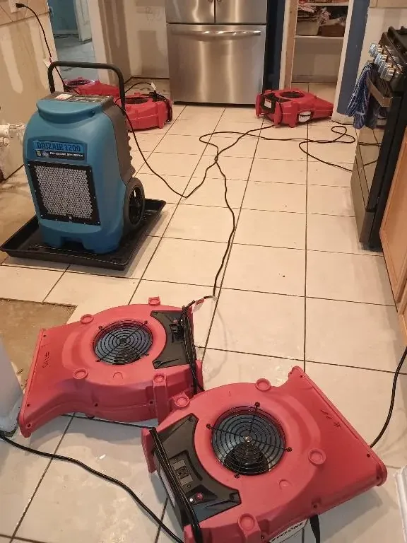 Air movers and a dehumidifier on tiled flooring