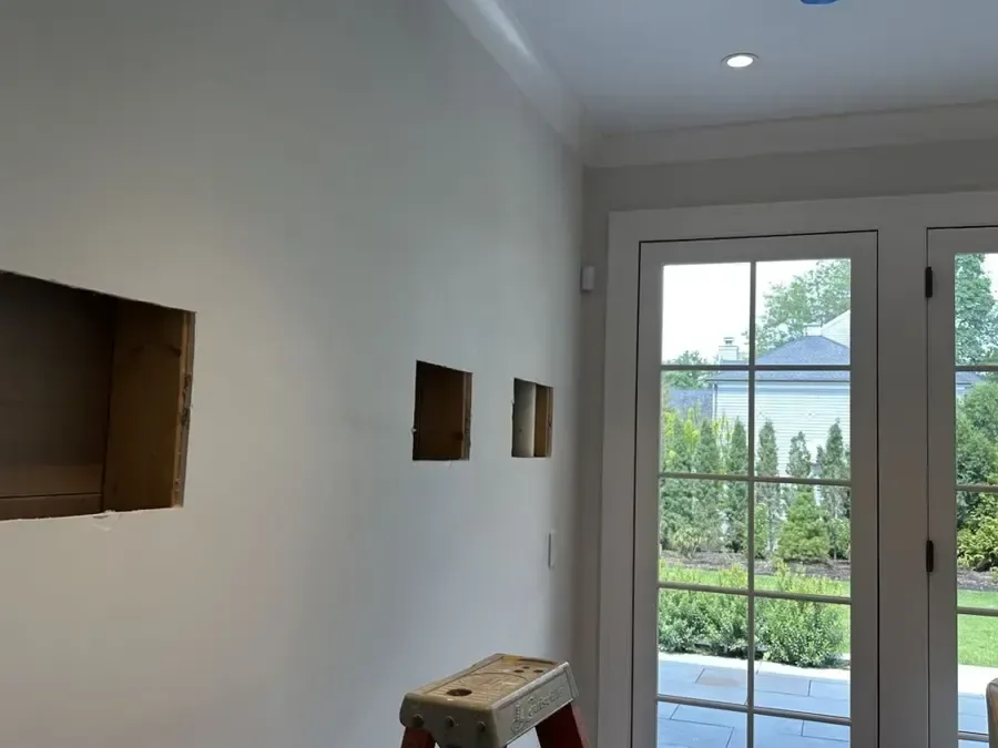 Rectangular openings exposing wall cavities beside a glazed exterior door